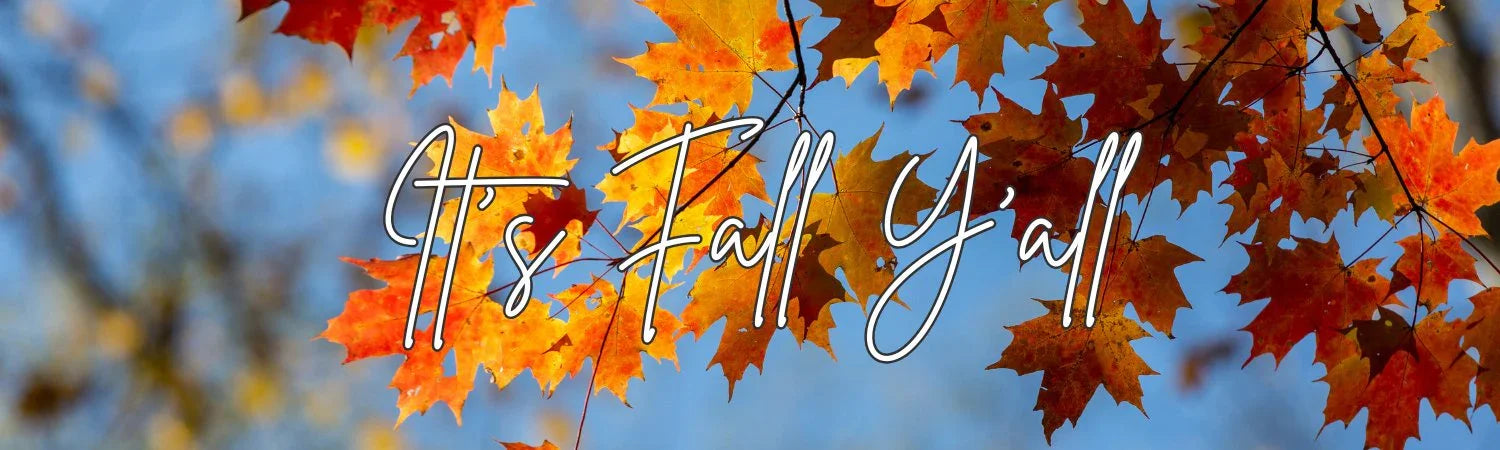 Orange and red autumn maple leaves with text It's Fall Y'all against a blue sky