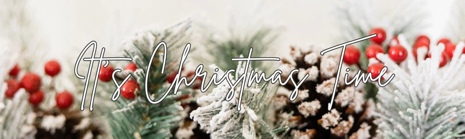 Close-up of snow-covered pine branches and red berries with text It's Christmas Time