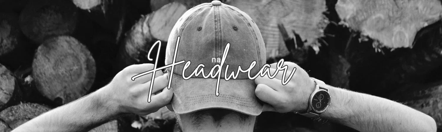 Black and white photo of person adjusting worn baseball cap with wood logs background, headwear fashion
