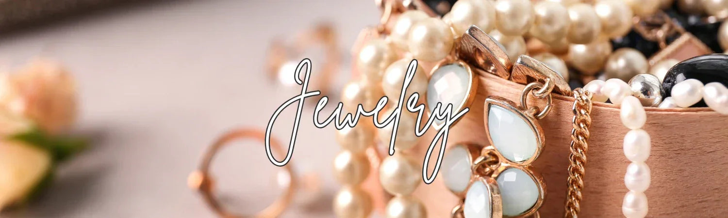 Close-up of assorted elegant jewelry with pearls and gold-tone pieces in a container