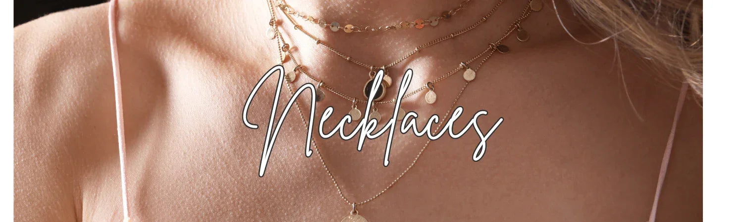 Close-up of layered gold necklaces with small round pendants on a woman's neckline, Fashion jewelry