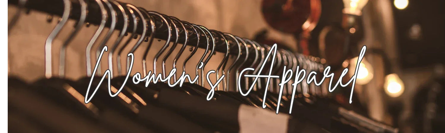 Black women's apparel hanging on metal rack in softly lit boutique retail setting